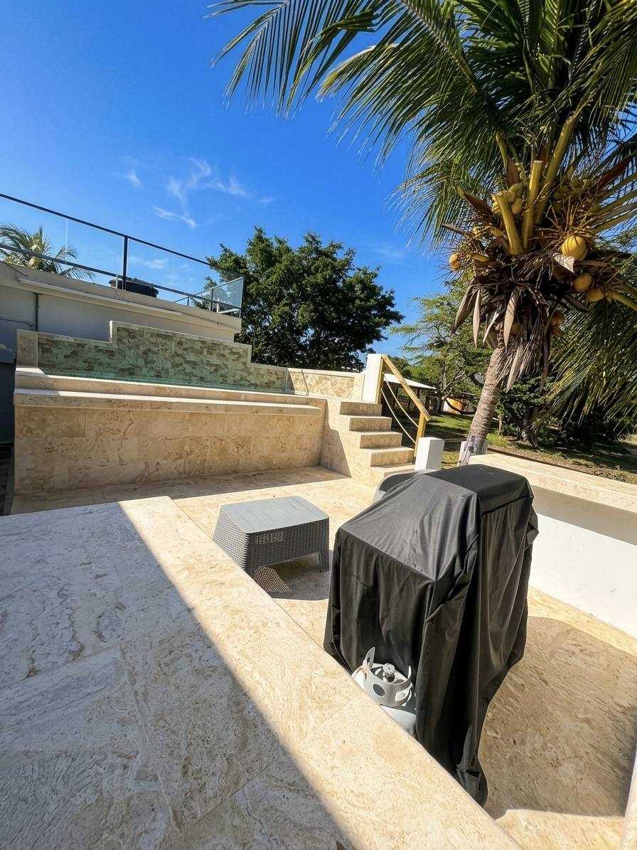 Terraza junto a la piscina y palmeras de Villa 2
